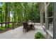 Outdoor patio with table and chairs has a private backyard view with mature trees at 4435 Pemberton Cv, Johns Creek, GA 30022