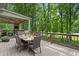 Outdoor living space with a dining area and seating overlooks a private backyard at 4435 Pemberton Cv, Johns Creek, GA 30022