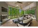 Covered outdoor living space with a fireplace, TV, grill, bar, plenty of seating, and a gorgeous backyard view at 4435 Pemberton Cv, Johns Creek, GA 30022