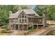 Beautiful home exterior featuring a spacious deck and expansive windows with wooded views at 4435 Pemberton Cv, Johns Creek, GA 30022