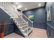 Staircase featuring a blue accent wall with a painting at 4435 Pemberton Cv, Johns Creek, GA 30022