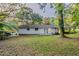 Exterior backyard view featuring a lush lawn, mature trees, and a house with french doors at 4748 Carson Sw Pass, Atlanta, GA 30331