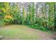 Large, grassy backyard with mature trees and lush vegetation, offering a private outdoor space at 4748 Carson Sw Pass, Atlanta, GA 30331