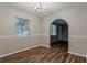 Sunny dining room features wood floors, wainscoting, modern light fixture, and natural light at 4748 Carson Sw Pass, Atlanta, GA 30331