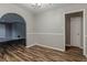 Light-filled dining room featuring wood floors, wainscoting, and an arched doorway to a living room at 4748 Carson Sw Pass, Atlanta, GA 30331