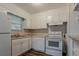 Functional kitchen with white cabinets, an oven/stove, dark hardware, and vinyl wood-look floors at 4748 Carson Sw Pass, Atlanta, GA 30331