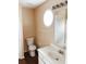 Bright bathroom with a white vanity, round mirror, and wood-look flooring at 301 Brookview Dr, Riverdale, GA 30274