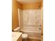 Bathroom featuring a white tub/shower combo with built-in shelving and a standard toilet at 301 Brookview Dr, Riverdale, GA 30274