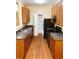 Functional kitchen with wood cabinets, black appliances, and hardwood floors at 301 Brookview Dr, Riverdale, GA 30274