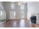 Spacious living room with hardwood flooring, a mirrored fireplace, and a large front-facing window at 4968 Windsor Downs Ln, Decatur, GA 30035