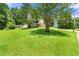 Well-manicured front yard with a lush lawn, mature trees, and a two-story house at 2706 Del Ridge Dr, Douglasville, GA 30135