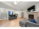 Bright living room with wood floors, a ceiling fan, a stone fireplace, and a large TV at 2706 Del Ridge Dr, Douglasville, GA 30135