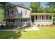 Charming two-story home with gray siding, black shutters, a covered front porch, and landscaped yard at 2880 Brett Nw Cir, Acworth, GA 30101