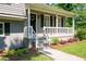 Inviting front porch with white railing, a wreath on the front door, and manicured landscaping at 2880 Brett Nw Cir, Acworth, GA 30101