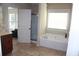 Bathroom featuring a tub with jets, a glass-door shower, and tiled floors, providing a comfortable place to relax at 730 Midway Ave, Canton, GA 30114