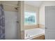 Relaxing bathroom showcasing tub and large window at 85 Shiver Blvd, Covington, GA 30016