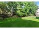 Serene backyard with mature trees surrounding a lush lawn and offering privacy and a connection with nature at 2539 Sagebrush Trl, Buford, GA 30519