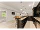 Basement bar area with granite counters, dark wood cabinets, and barstool seating next to a Gathering room at 2539 Sagebrush Trl, Buford, GA 30519