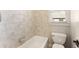 Bright bathroom featuring a tiled shower, bathtub and white toilet at 2539 Sagebrush Trl, Buford, GA 30519