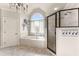 Bright bathroom featuring a soaking tub, shower, and an arched window at 2539 Sagebrush Trl, Buford, GA 30519