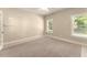 Bedroom with neutral paint, tile baseboards, two windows and carpet flooring at 2539 Sagebrush Trl, Buford, GA 30519