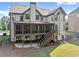 Backyard view of the home featuring a screened-in porch, steps down to a patio, and manicured landscaping at 2539 Sagebrush Trl, Buford, GA 30519