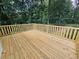 Large outdoor deck with wood railing surrounded by mature trees and landscaping at 312 N Briar Rdg, Woodstock, GA 30189