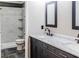 Stylish bathroom with a marble countertop, dual sinks, and a tiled shower with glass shelving at 312 N Briar Rdg, Woodstock, GA 30189