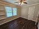 Cozy bedroom with hardwood floors, ceiling fan, closet, and a large window at 312 N Briar Rdg, Woodstock, GA 30189