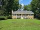 Charming single-story home featuring a covered front porch, well-maintained lawn, and mature trees at 312 N Briar Rdg, Woodstock, GA 30189