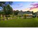 Expansive backyard with fire pit, patio, mature trees, and well manicured lawn, ideal for gatherings at 110 Village Ct, Woodstock, GA 30188