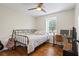 Bedroom featuring wood floors, a metal bed frame, a desk with a computer, and a ceiling fan at 110 Village Ct, Woodstock, GA 30188