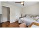 Bedroom with wood floors, a metal bed frame, a desk, a ceiling fan, and natural light at 110 Village Ct, Woodstock, GA 30188
