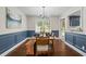 Stylish dining room featuring wainscoting, hardwood floors, and a modern chandelier for elegant meals at 110 Village Ct, Woodstock, GA 30188