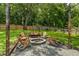 Backyard firepit with wooden chairs on a gravel bed provides perfect gathering place at 110 Village Ct, Woodstock, GA 30188