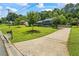Charming home with a well-manicured lawn, mature trees, and a long driveway leading to the residence at 110 Village Ct, Woodstock, GA 30188