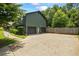 Exterior view of a two-car garage with a spacious driveway and lush greenery surrounding the property at 110 Village Ct, Woodstock, GA 30188