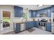 Stylish kitchen featuring blue cabinets, stainless steel appliances, and a view to the backyard at 110 Village Ct, Woodstock, GA 30188