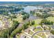 Stunning aerial view of a residential neighborhood featuring large homes, a lake, and lush greenery at 1405 Rainey Way, Hampton, GA 30228