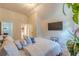 A well lit bedroom boasting a TV, plants, and a comfortable bed, creating a modern and peaceful retreat at 1405 Rainey Way, Hampton, GA 30228