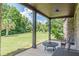 Inviting covered patio with outdoor seating overlooking a spacious and well-maintained lawn and landscaped backyard at 1405 Rainey Way, Hampton, GA 30228