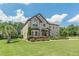 Beautiful two-story brick home featuring a manicured lawn, mature landscaping, and a welcoming entrance at 1405 Rainey Way, Hampton, GA 30228