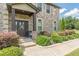 Charming front porch with decorative door, a chair and lush landscaping, welcoming guests to this brick home at 1405 Rainey Way, Hampton, GA 30228