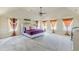 Spacious main bedroom featuring plush carpeting, a ceiling fan, and an abundance of natural light from multiple windows at 1405 Rainey Way, Hampton, GA 30228
