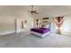 Large, carpeted primary bedroom with ensuite bathroom and ceiling fan at 1405 Rainey Way, Hampton, GA 30228