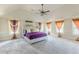 A spacious and bright main bedroom has a large area rug, multiple windows, and high ceilings at 1405 Rainey Way, Hampton, GA 30228