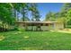 Exterior view of the back of the home with a spacious yard surrounded by trees at 4235 Apache Se Dr, Acworth, GA 30102