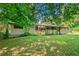 Exterior view of the back of the home with a spacious yard surrounded by trees at 4235 Apache Se Dr, Acworth, GA 30102