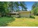 Exterior view of the back of the home with a spacious yard surrounded by trees at 4235 Apache Se Dr, Acworth, GA 30102