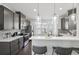 Modern kitchen with gray cabinets, stainless steel appliances, quartz countertops, stylish pendant lighting and a breakfast bar at 5534 Radford Loop, Fairburn, GA 30213